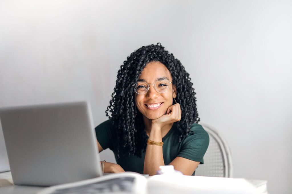 zipwp-image-3769021 Happy ethnic woman sitting at table with laptop